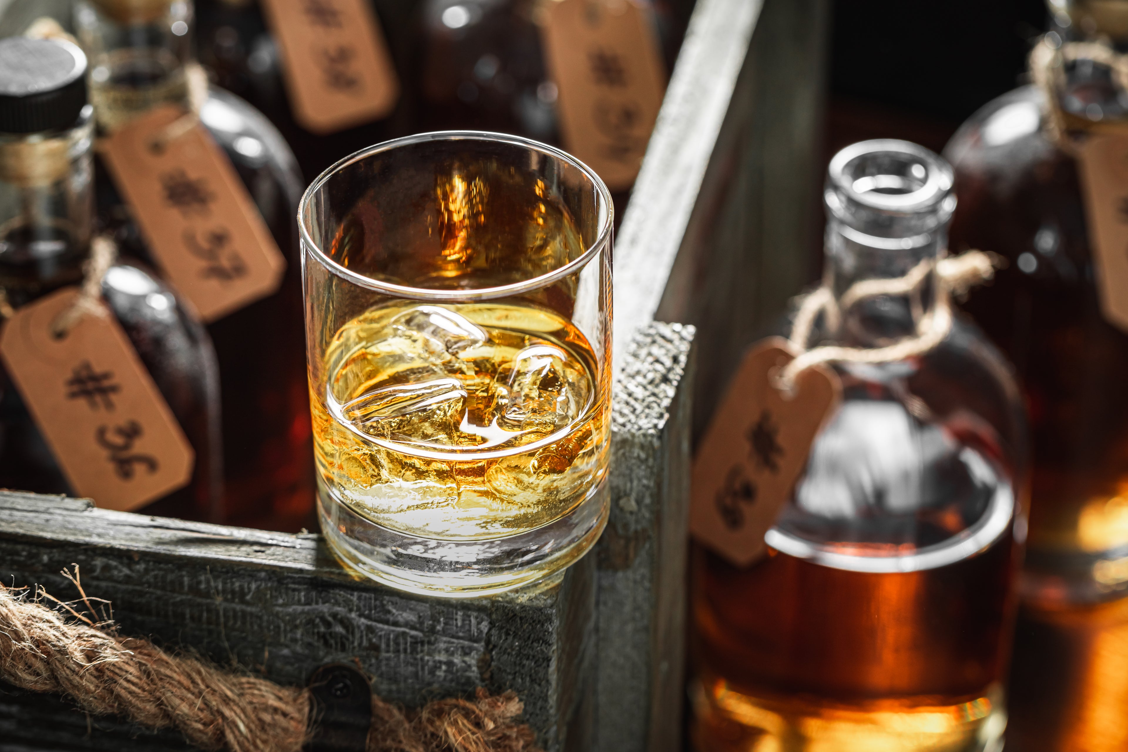 Glass of whiskey with bottles in the background